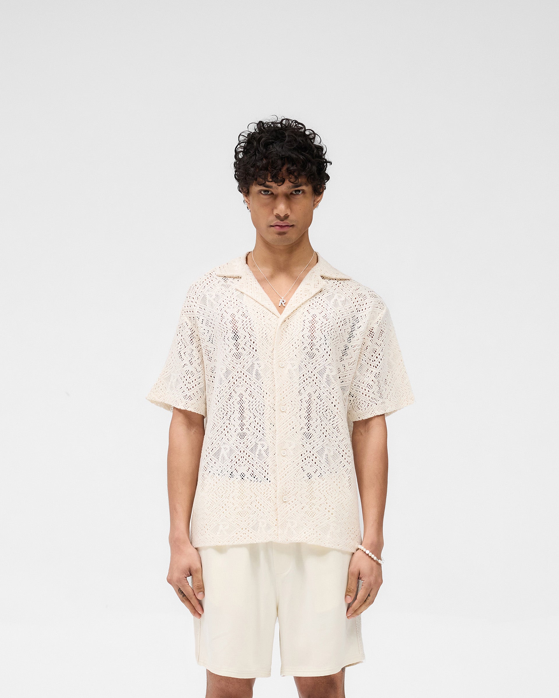 Man wearing an off-white crochet shirt on a plain white background | All Over Crochet Shirt in Off White | Open-knit crochet shirt with