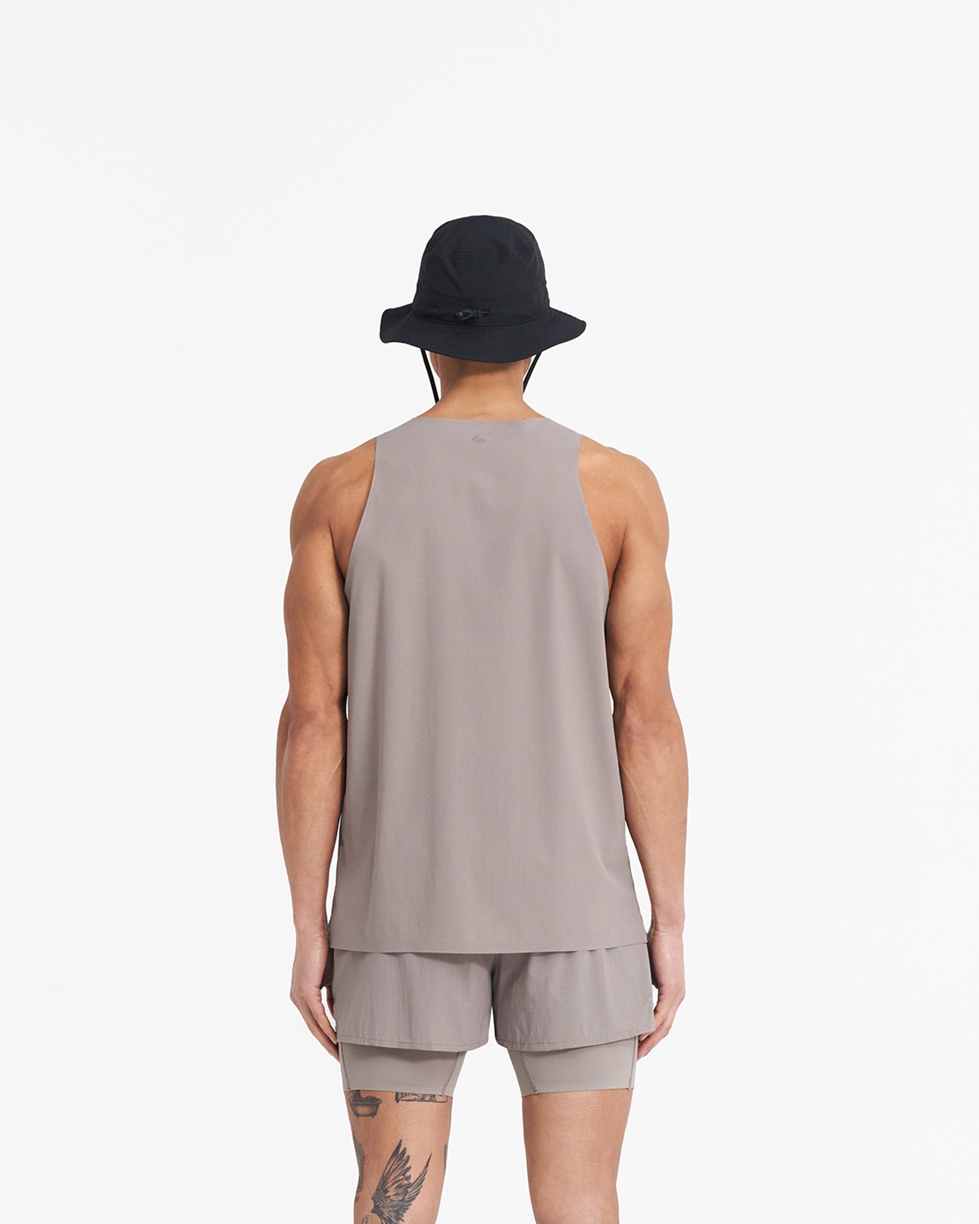Man wearing a grey perforated training vest on a plain white background | 247 Singlet in Cinder | Stretch ripstop vest with bonded hems and flatlock seams | 247 T-Shirts | Represent Clo