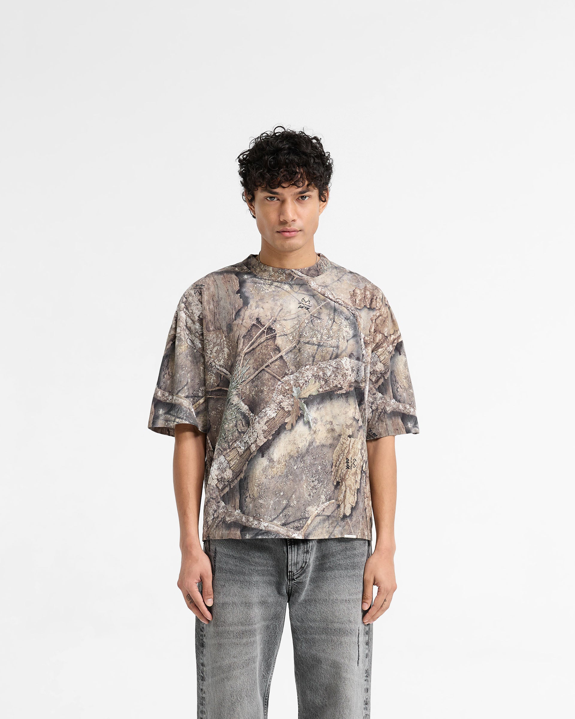 Man wearing a camo t-shirt on a plain white background | Realtree Camo T-Shirt in Camo | Boxy fit oversized t-shirt with faded print and carbon finish | SS25 T-Shirts | Represent Clo