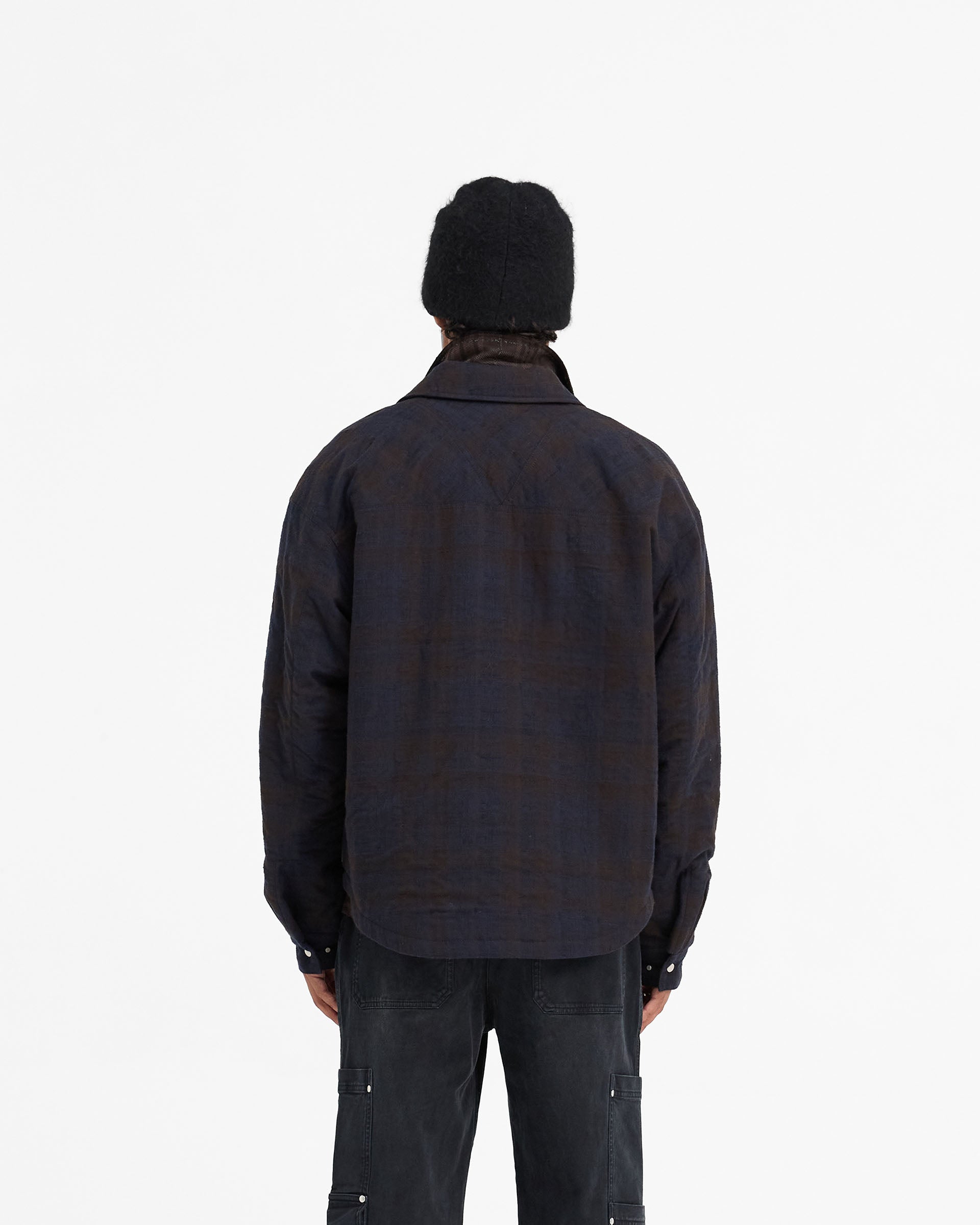 Man wearing a navy overshirt on a plain white background | Wadded Zip Overshirt in Midnight Navy | Wadded overshirt with zip closure and pockets | FW24 Shirts | Represent Clo